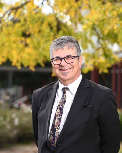 Photo of Nick Adamou, college principal, smiling at the camera